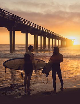 Surfers in California sunset