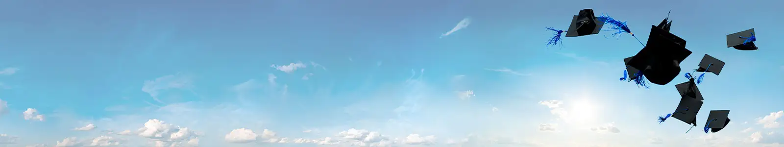 Graduation hats flying against a blue sky
